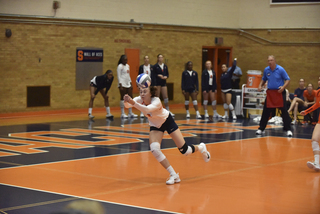 A Syracuse player reaches out to hit the ball at the back of the court. 
