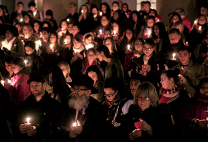 Members of the Syracuse University community stand on the front steps of Hendricks Chapel to participate in a candlelight vigil to remember and honor the victims and survivors of violence against women. The silent vigil was part of the SU Rising event held on Thursday.