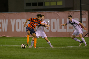 Tajon Buchanan keeps the ball away from Akron defenders in last year's matchup between the two teams.