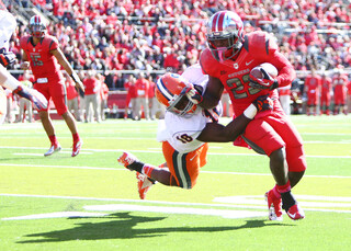 Rutgers running back Jawan Jamison gives a stiff arm to Syracuse linebacker Siriki Diabate as he runs upfield.