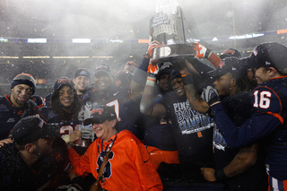 The Syracuse football team poses with Chancellor Nancy Cantor in a ceremony after the game.