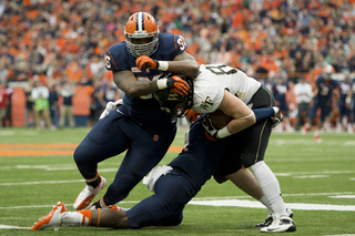 Orange defensive tackle Jay Bromley helps cornerback Brandon Reddish drag down a Demon Deacon.