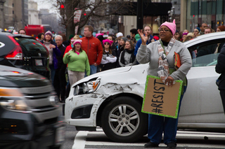 A woman holds a sign in a street in Washington D.C.